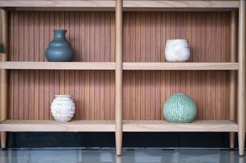Minimalist wooden shelves hold ceramic vases