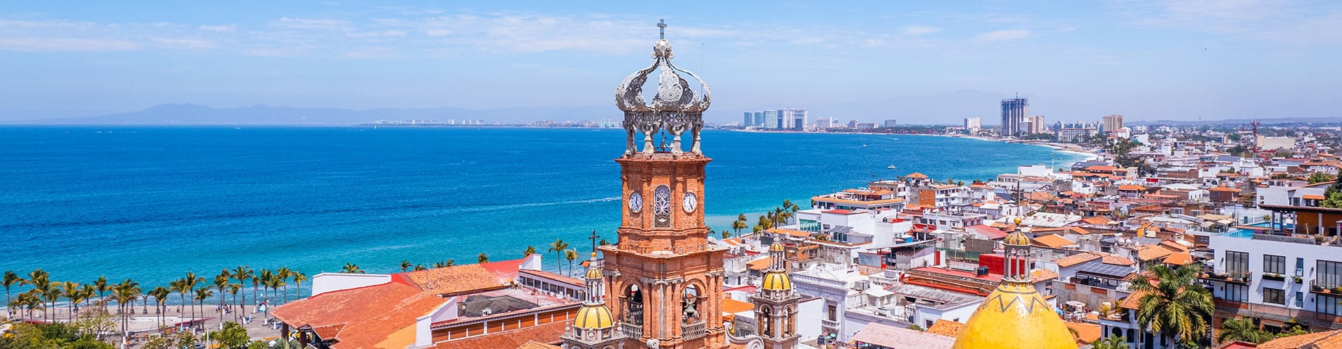 Aerial view of Puerto Vallartas iconic clock tower overlooking the Pacific Ocean, beaches, and coastal city